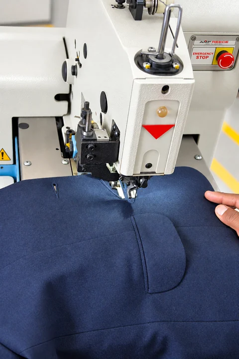 Retouched portrait view of the AMF Reece eyelet buttonhole machine and navy blazer