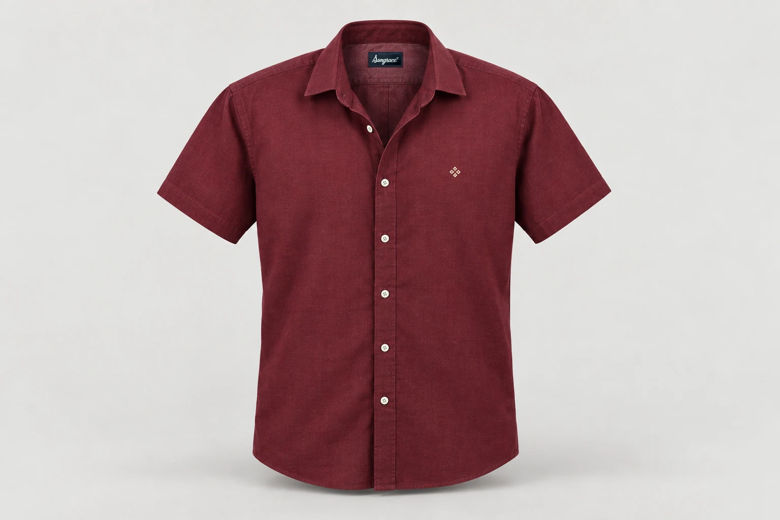 Corporate Shirts — Muted burgundy unisex short-sleeve shirt, semi-spread collar, no pocket, original tiny cream geometric chest embroidery. product front. Illustrative catalogue concept.
