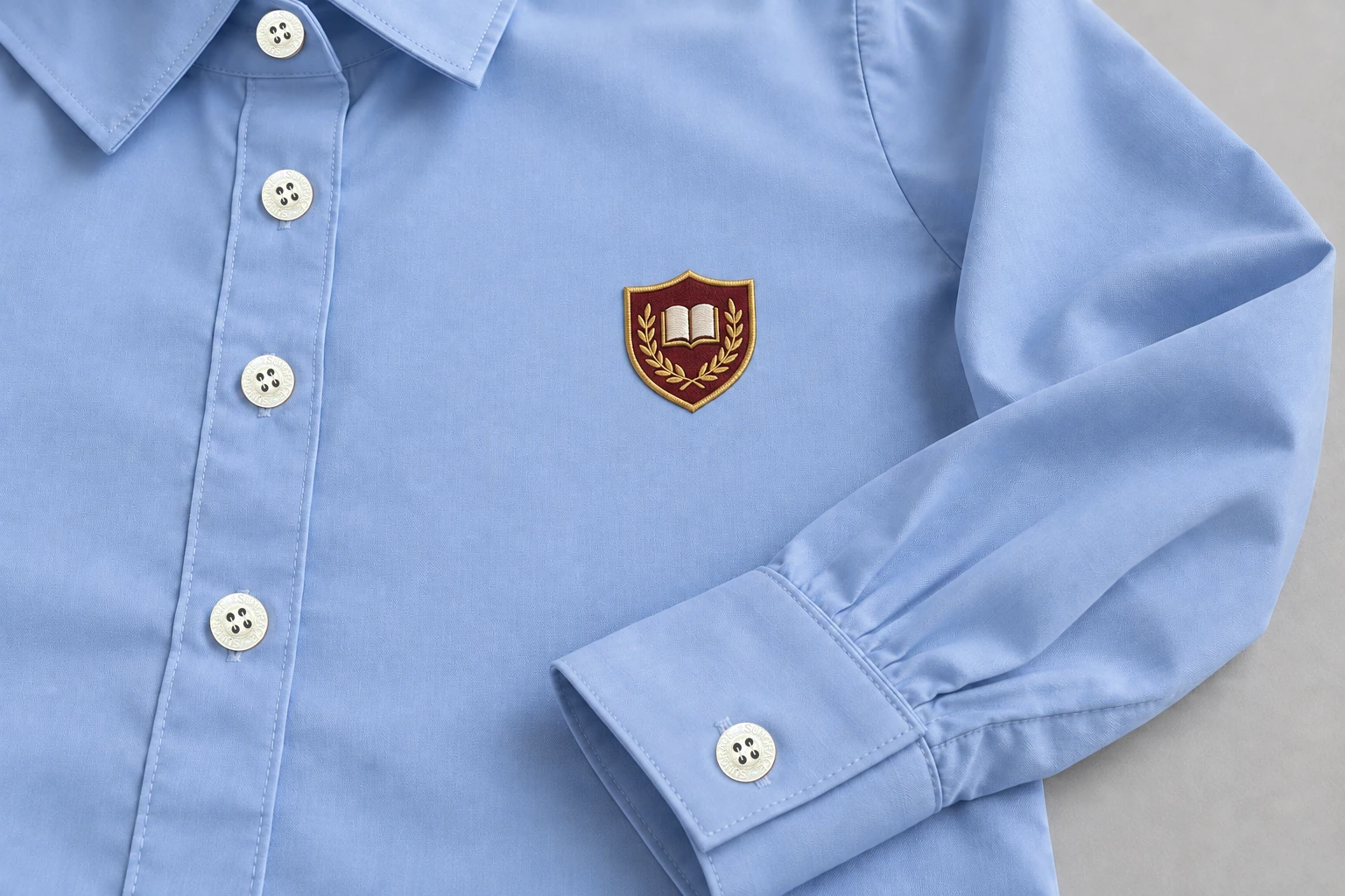 Full-Sleeve School Blouses — powder-blue sample crest pocket with visible button cuff. close embroidery detail photograph. Illustrative catalogue concept.