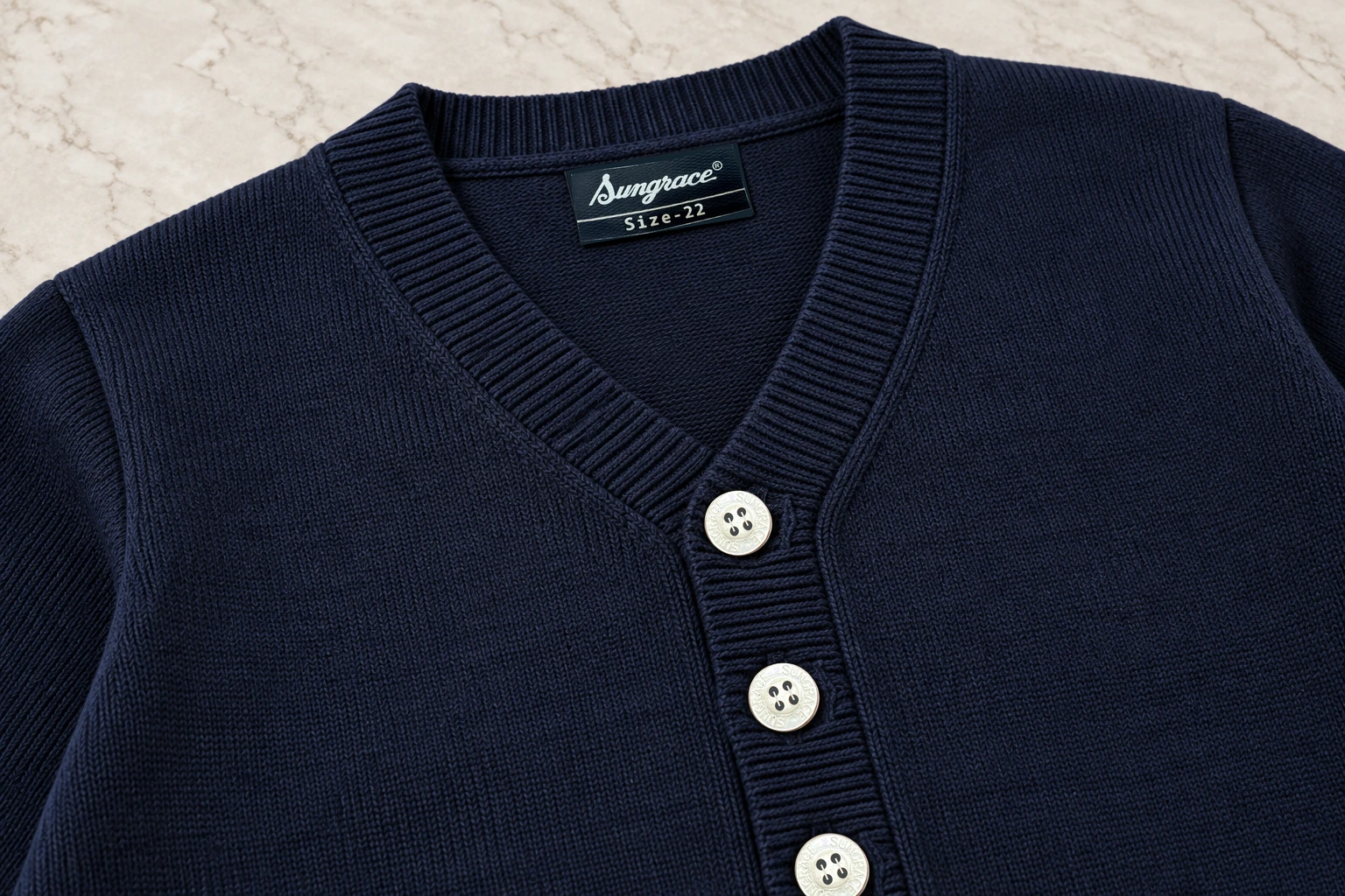 Full-Sleeve School Cardigans — Navy cardigan · neck and button construction. detail. Illustrative catalogue concept.