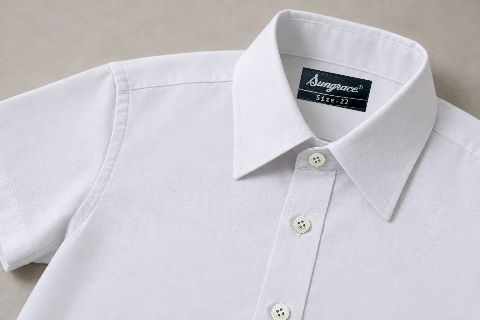 Half-Sleeve School Shirts — white shirt collar, placket, buttons and shoulder seam. macro construction detail photograph. Illustrative catalogue concept.