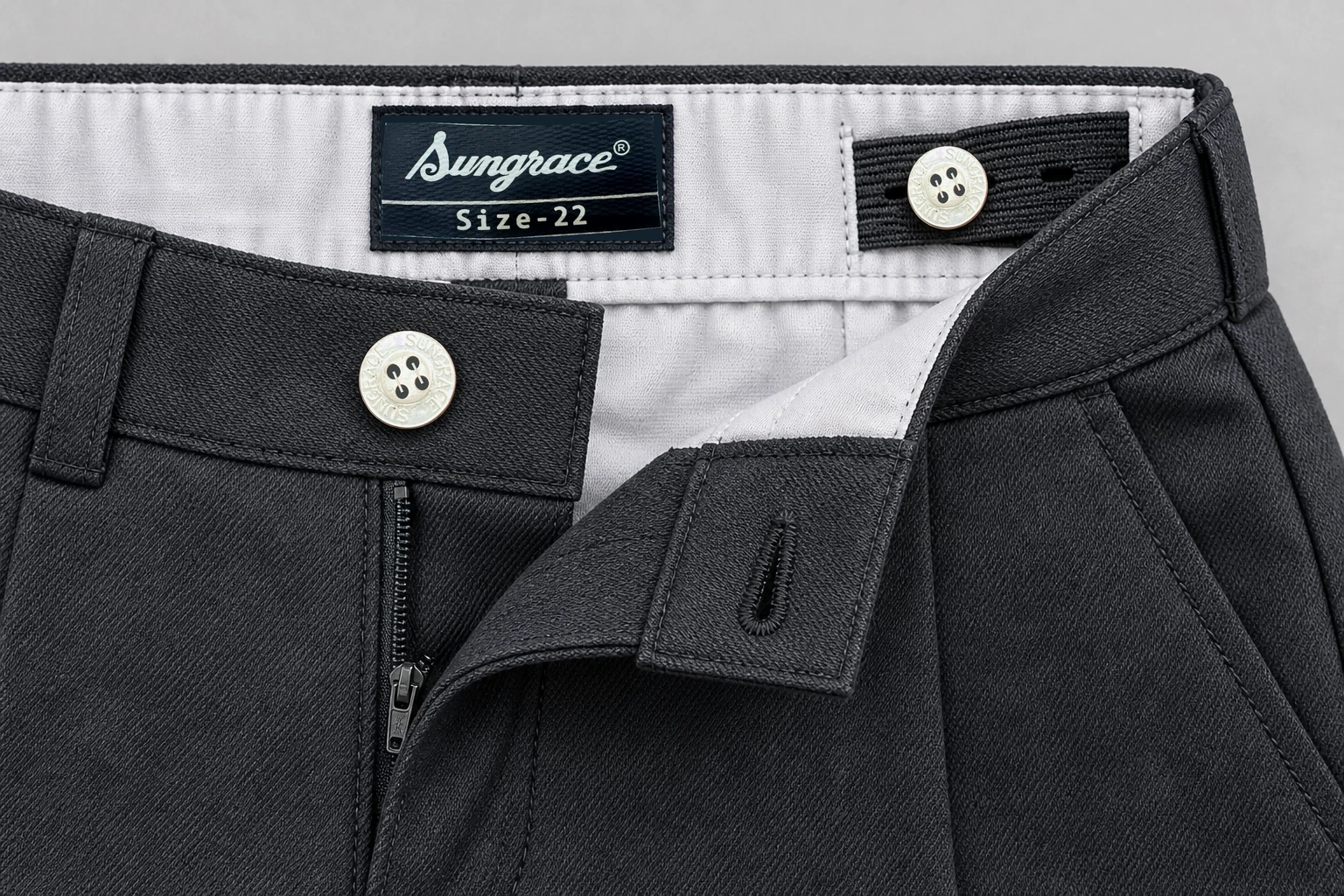 School Shorts — Charcoal adjustable waistband. macro waistband and closure construction detail photograph. Illustrative catalogue concept.