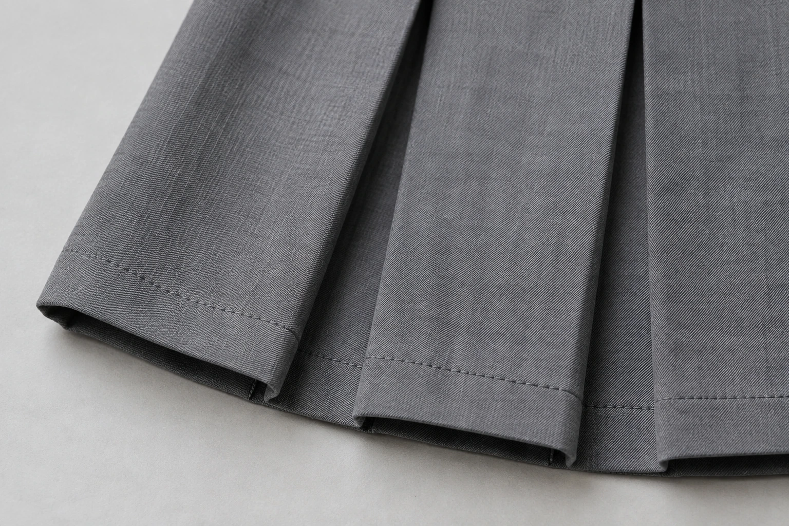 School Skirts — Grey knife pleat hem. macro pleat and hem construction detail photograph. Illustrative catalogue concept.