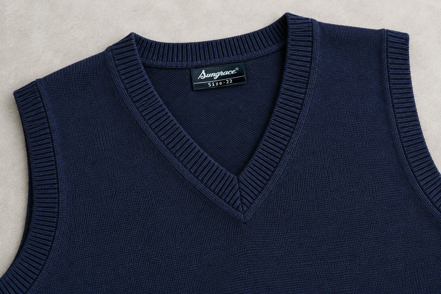 Sleeveless School Sweaters — Navy V-neck rib and inside label construction. detail. Illustrative catalogue concept.