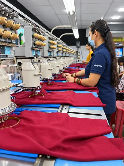 Women working with burgundy garments on Sungrace’s in-house embroidery machines