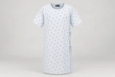 Patient Gowns — Unisex white knee-length patient gown with subtle small original blue leaf print, short sleeves and rear overlap ties. product front. Illustrative catalogue concept.