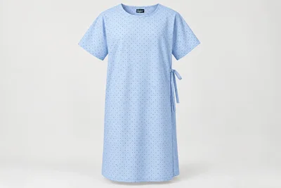 Patient Gowns — Unisex pale-blue knee-length patient gown with tiny original navy dot print, short sleeves and round neck. product front. Illustrative catalogue concept.