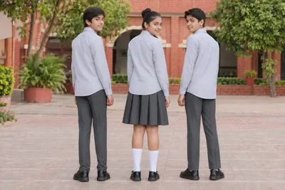 Full-Sleeve School Shirts — Fine grey stripe; two boys and one girl. full-length rear three-quarter group location photograph. Illustrative catalogue concept.