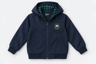 School Jackets for Small Children — navy cotton twill school jacket with simple hood laid flat showing small green and navy checked lining, front zip, no drawstrings, cuffed sleeves. product. Illustrative catalogue concept.