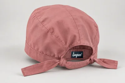 Scrub Caps — Dusty-rose woven scrub cap with fuller crown and tie-back band. product rear three-quarter. Illustrative catalogue concept.