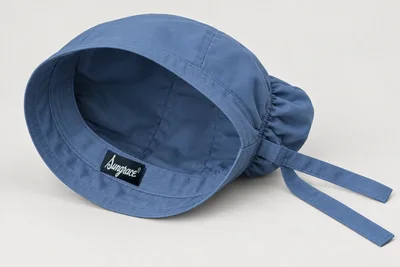 Scrub Caps — Steel-blue scrub cap with long-hair rear pouch and adjustable tie-back band. product rear three-quarter. Illustrative catalogue concept.